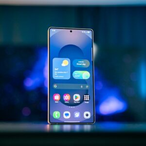 A cell phone sitting on top of a table next to a lamp