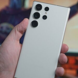 a person holding a white cell phone in their hand